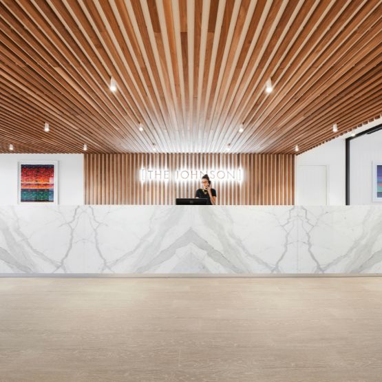 A large hotel reception space with a marble front desk